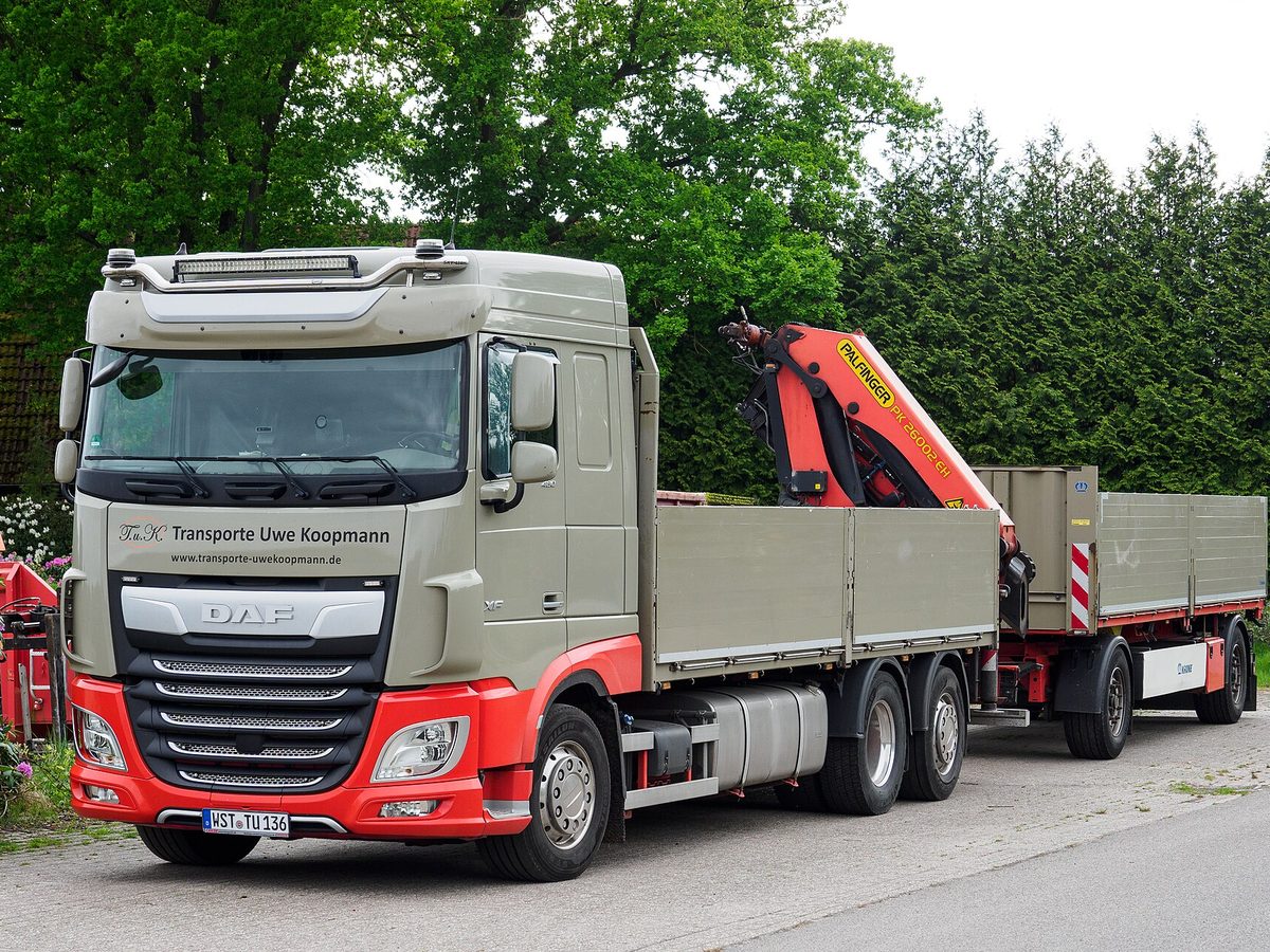 Rigid service truck with drop-side tray and truck-mounted crane