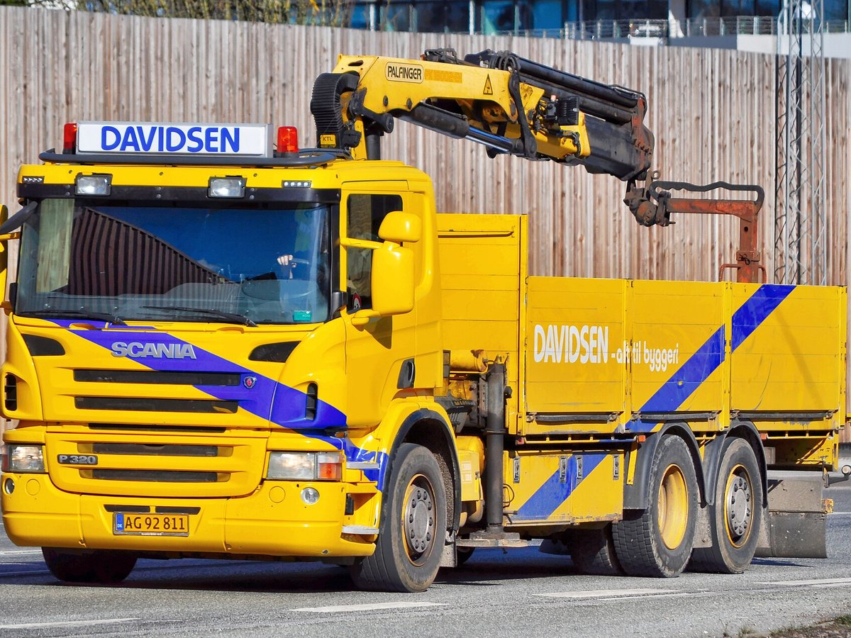 Tipper truck fitted with a rear-mounted knuckle-boom crane
